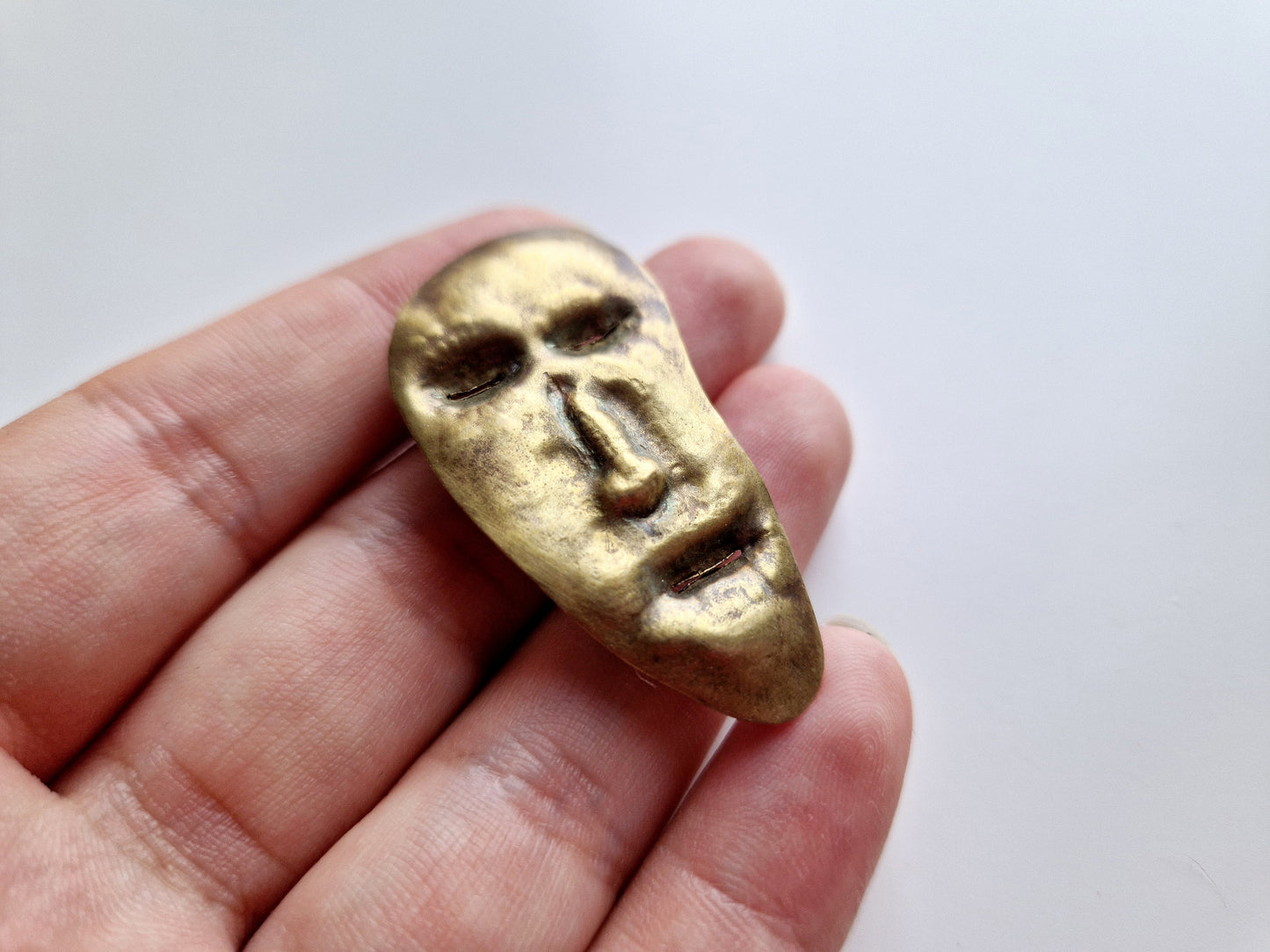 broșă—insignă cu un chip cizelat manual (mascaron)
