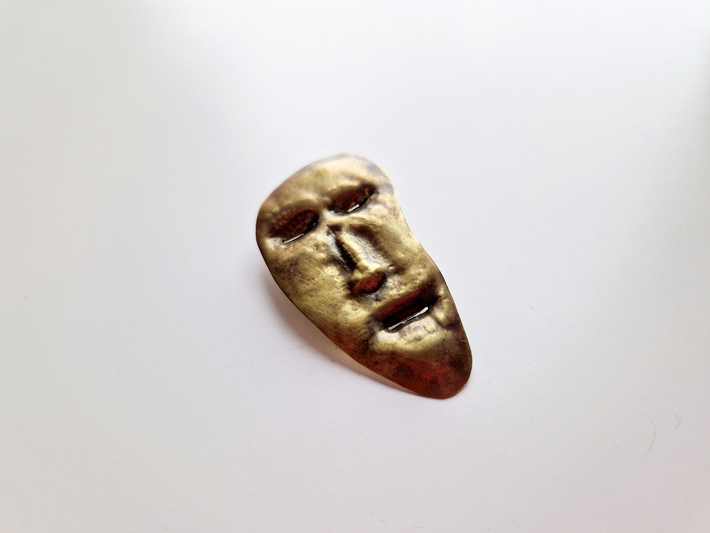 broșă—insignă cu un chip cizelat manual (mascaron)